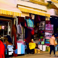 Painting of a Moroccan street stall filled with colorful goods under a yellow awning, with people shopping and walking past. The following images show the same artwork displayed in different interior settings.