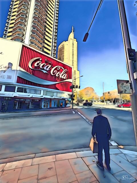 A person stands at a street corner beneath the iconic Coca-Cola sign in Kings Cross, Potts Point, with high-rise buildings and long shadows across the pavement. The following images feature the same artwork in different interior settings.